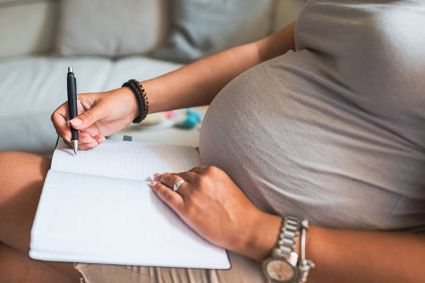 istock Pregnant woman making to do list 1288809131
