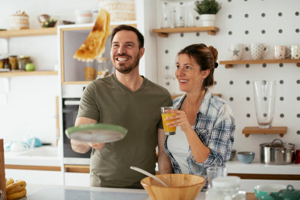 istock Husband and wife making pancakes at home. 1288810724