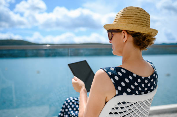 женщина наслаждается балконом и с помощью цифрового планшета - e reader digital tablet cafe reading стоковые фото и изображения
