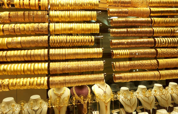 istock Rows of gold bracelets hang on racks 1288810873