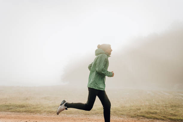istock Young man jogging on cold foggy morning 1288811794