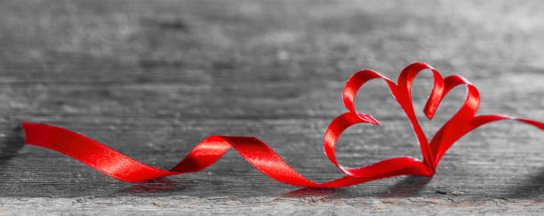 istock Red ribbon hearts on wood 1288811928
