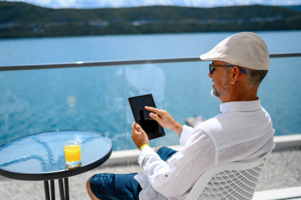 человек наслаждается балконом и использует цифровой планшет - e reader digital tablet cafe reading стоковые фото и изображения