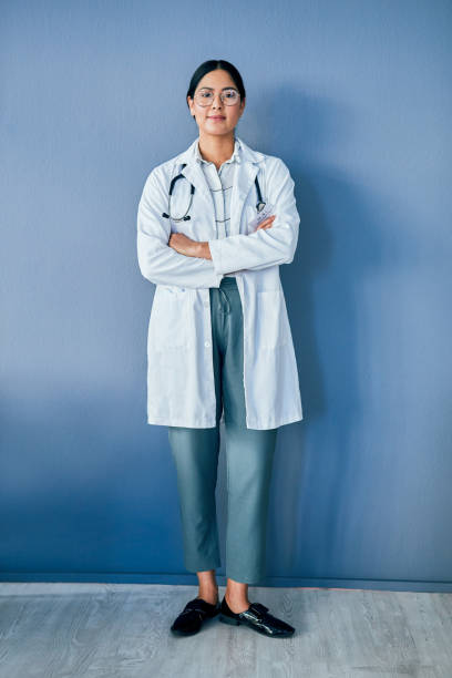 My mission is to make you better Studio portrait of a confident young doctor standing against a blue background photography healthcare and medicine studio shot vertical stock pictures, royalty-free photos & images