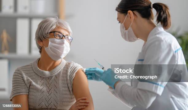 Doctor Giving A Senior Woman A Vaccination Stock Photo - Download Image Now - Vaccination, COVID-19 Vaccine, Senior Adult