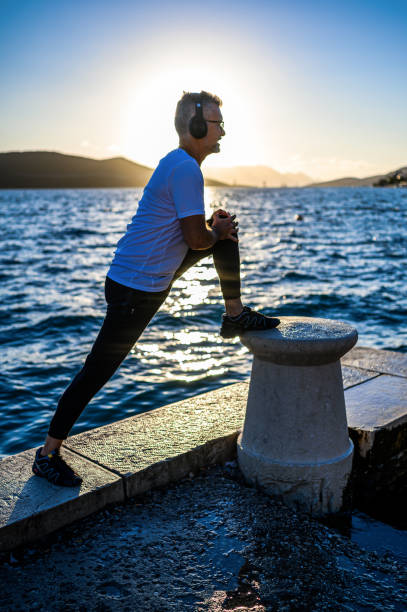 istock Man stretching on the shores 1288814779