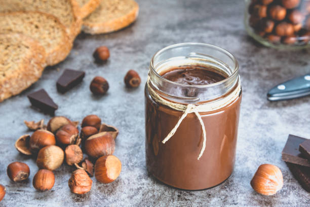 istock Homemade hazelnut chocolate butter, hazelnut, dark chocolate, on black stone background 1288816779