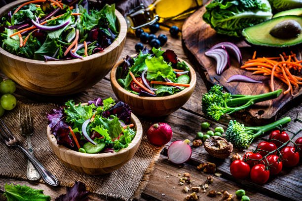 istock Frash salad bowls with ingredients on rustic wooden table 1288818048