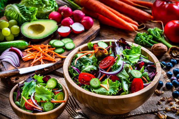 istock Frash salad bowls with ingredients on rustic wooden table 1288818092