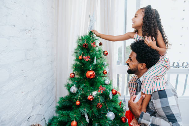 istock Father and daughter decorating Christmas tree 1288819492