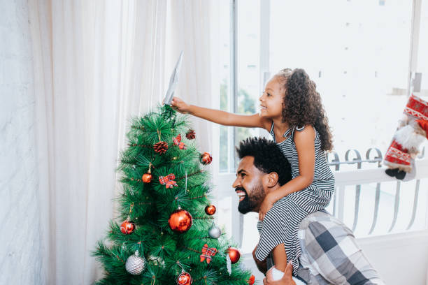 istock Father and daughter decorating Christmas tree 1288819494