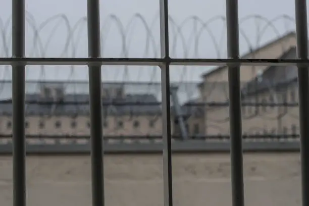 a prison window and razor wire in front of it
