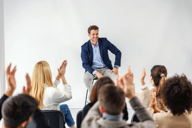 istock Smiling ceo sitting in boardroom with his employees and having speech. Employees clapping. 1288821911