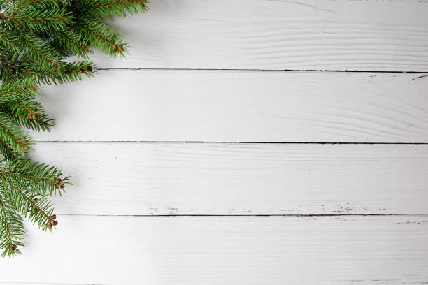 istock White Christmas card with pine tree on white wood 1288824911