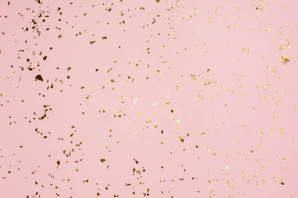 istock Golden sparkles on a pink paper background. 1288827089