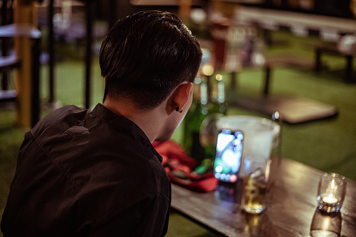 Stressed drunk man sitting alone with glass of beer in bar