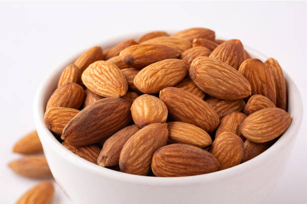 istock Close-up of fresh raw almonds on a white background 1288829842