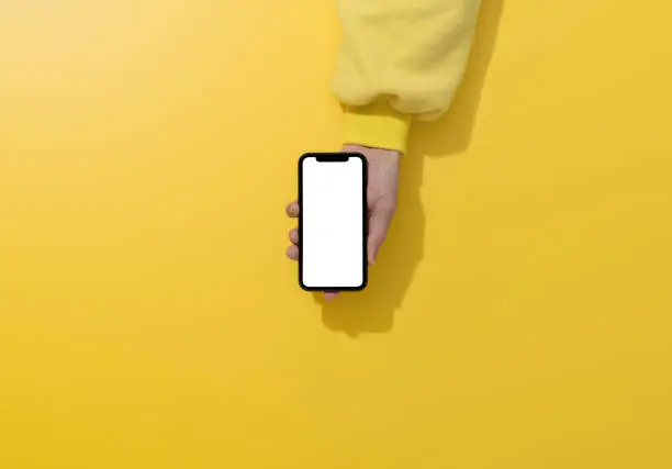 Hands holding smart phone on yellow background,  mockup concepts