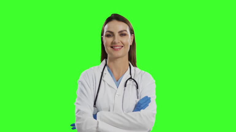 Mature doctor showing pills, green screen. Happy male doctor showing pills in bl