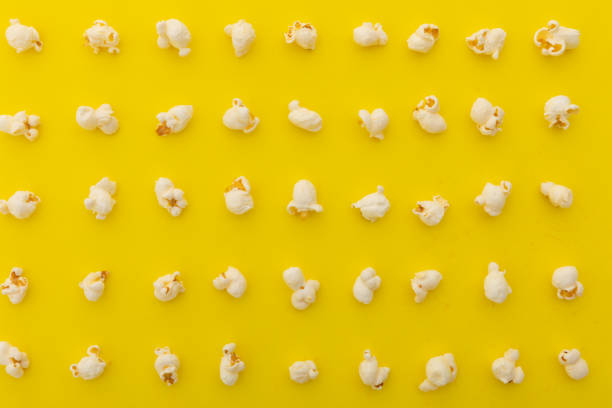 istock High angle view of popcorn in multiple rows on yellow background 1288832442