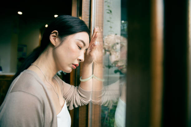 istock Sadness Woman By Window 1288835349