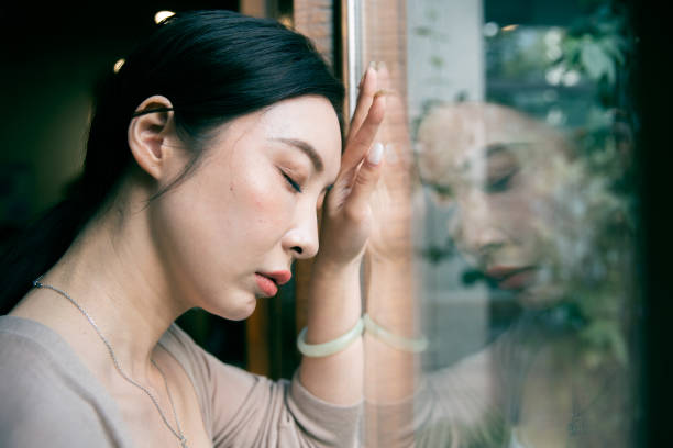 istock Sadness Woman By Window 1288836139