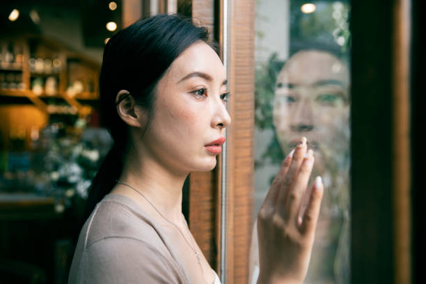 istock Sadness Woman By Window 1288836142