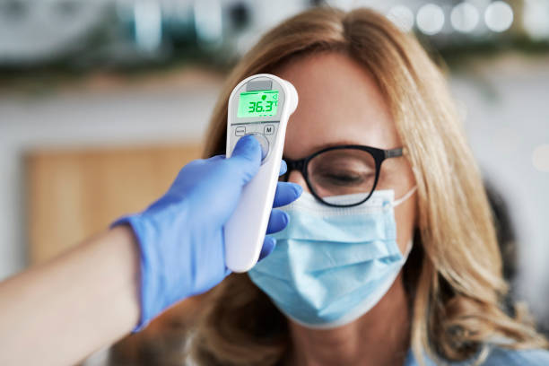 istock Close up of using thermometer gun to check body temperature 1288838063