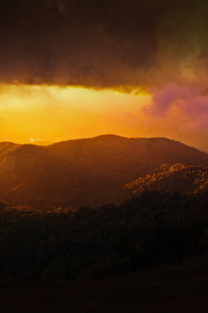 istock Dramatic rainstorm hiding the setting sun and mountain ridge. 1288839439