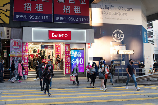 Hong Kong - December 01, 2020: Street view in Mongkok. People walking on the street and wearing masks to protect coronavirus spread in the air. Mongkok is one of the major shopping areas in Hong Kong.