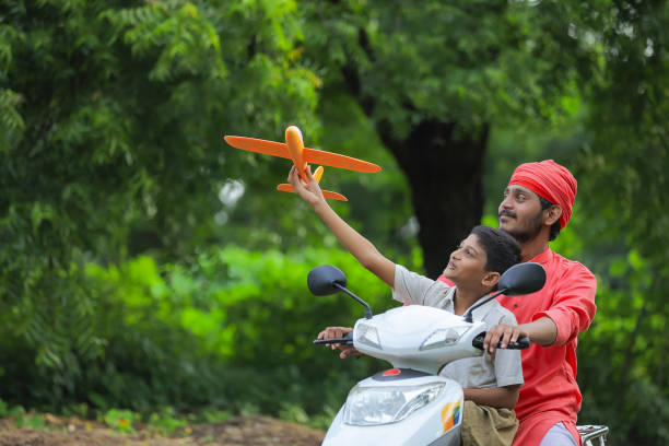 Young indian farmer dropping his child to school.