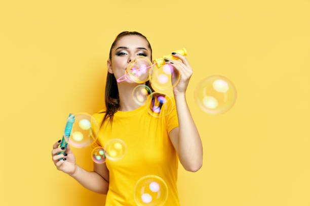 istock Happy beautiful woman blowing soap bubbles 1288842392