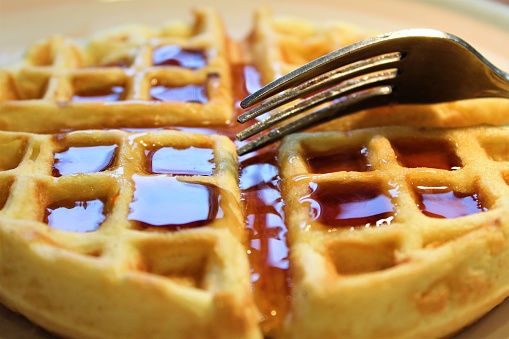 First Person View of Delicious Belgian Waffle - Best Food Art for Website, Food Blogs, or as an Engaging Art Element in Your Advertising - Best Breakfast Backgrounds - Delicious Breakfast Choice - Engaging Menu Photos - Waffle is Covered in Maple Syrup - Close View of My Breakfast Meal - Let Us Eat Our Breakfast - A Golden Brown Waffle is Ready Now - Tasty Breakfast is Served by My Waitress - Eating a Waffle