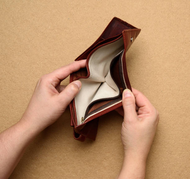 istock two female hands hold brown leather open empty wallet for cash 1288842918