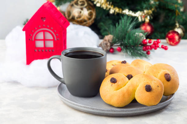 traditionella svenska och skandinaviska julsaffransbullar lussekatter med kopp kaffe, juldekoration på bakgrund, horisontell - lussebulle bildbanksfoton och bilder