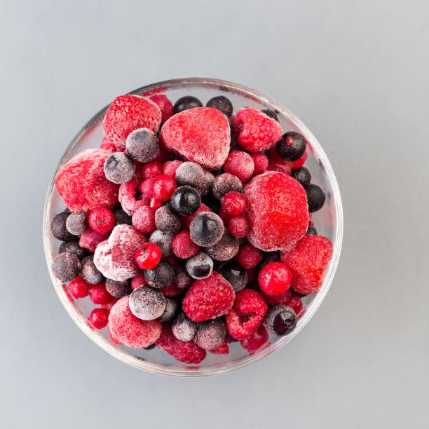 istock Frozen berries in a glass bowl, top view, square format, closeup 1288843757