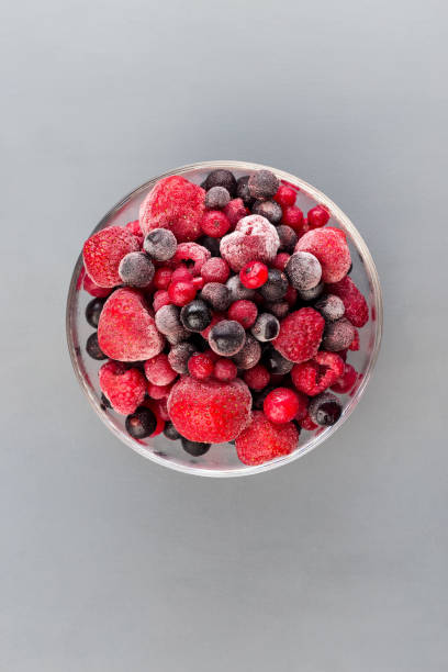 istock Frozen berries in glass bowl, raspberry, strawberry, cranberry and black currant, vertical, copy space, top view 1288843776