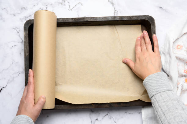 istock two female hands cover with brown parchment paper an iron rectangular baking sheet 1288843879