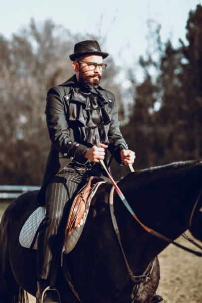 istock Stylish Male Commanding Authority To His Black Stallion On Ranch 1288844079