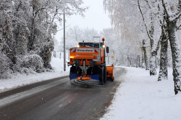 schneepflug ist streusalz oder enteisungchemikalien auf dem bürgersteig in der stadt. - winterdienst stock-fotos und bilder