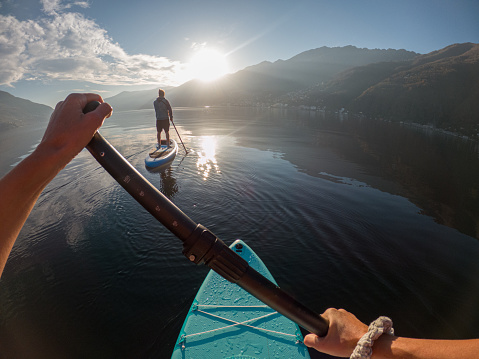 Man paddling with her, mountains in distance