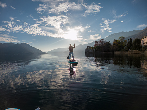 First person point of view of a woman paddling on a stand up paddle board