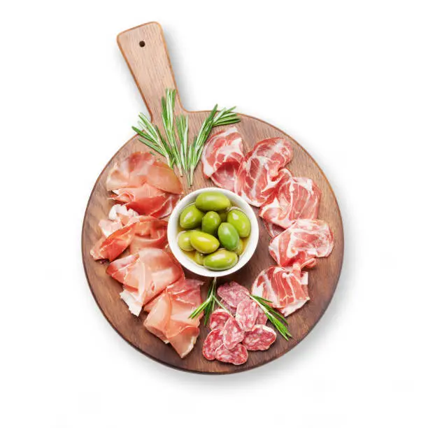Traditional spanish jamon, prosciutto crudo, italian salami, parma ham and olives. Antipasto board. Top view flat lay. Isolated on white background