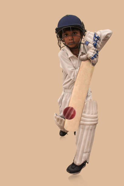 A boy in cricket uniform playing Cricket