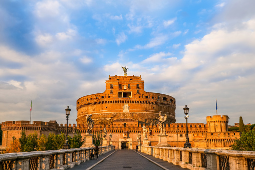 Rome, Italy, November 25 -- The warm colors of a autumn sunset on the Castel Sant'Angelo, in the heart of Rome, creating a pictorial mood. Built around 123 AD as a sepulcher for Emperor Hadrian and his family, the current Castel Sant'Angelo was used as a fortress, prison and refuge by the Popes due his proximity with the Vatican. It is currently owned by the Italian state and is used for visits and cultural events. Image in High Definition format.Image in High Definition format.
