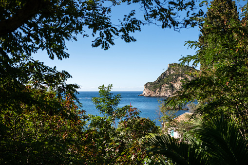 Corfu, Greece: View through trees to the Mediterranean on a sunny day.
