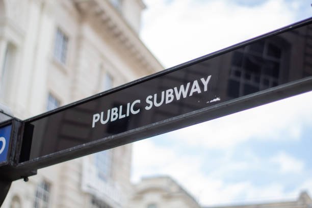 istock Black public subway sign with a blurry building as background 1288849185