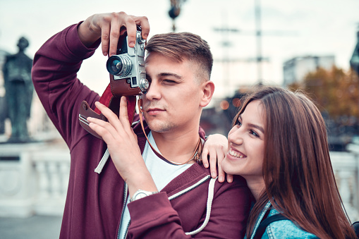 Cute Couple Enjoying Time Spent Together While Photographing In City