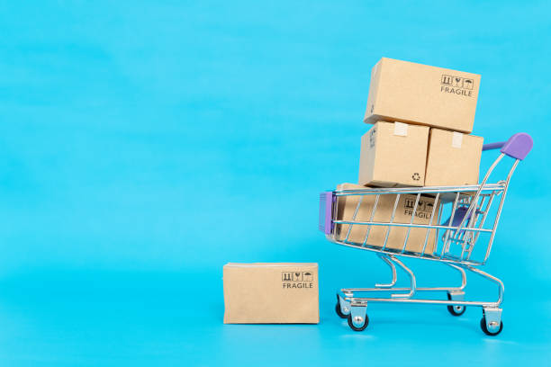 istock Paper boxes in a trolley on blue background .Online shopping or ecommmerce concept and delivery service concept with copy space for your design. 1288851485