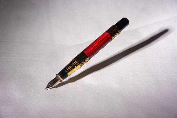 istock Antique fountain pen, fountain pen released in the air with drop shadow on light gray background, selective focus. 1288856482